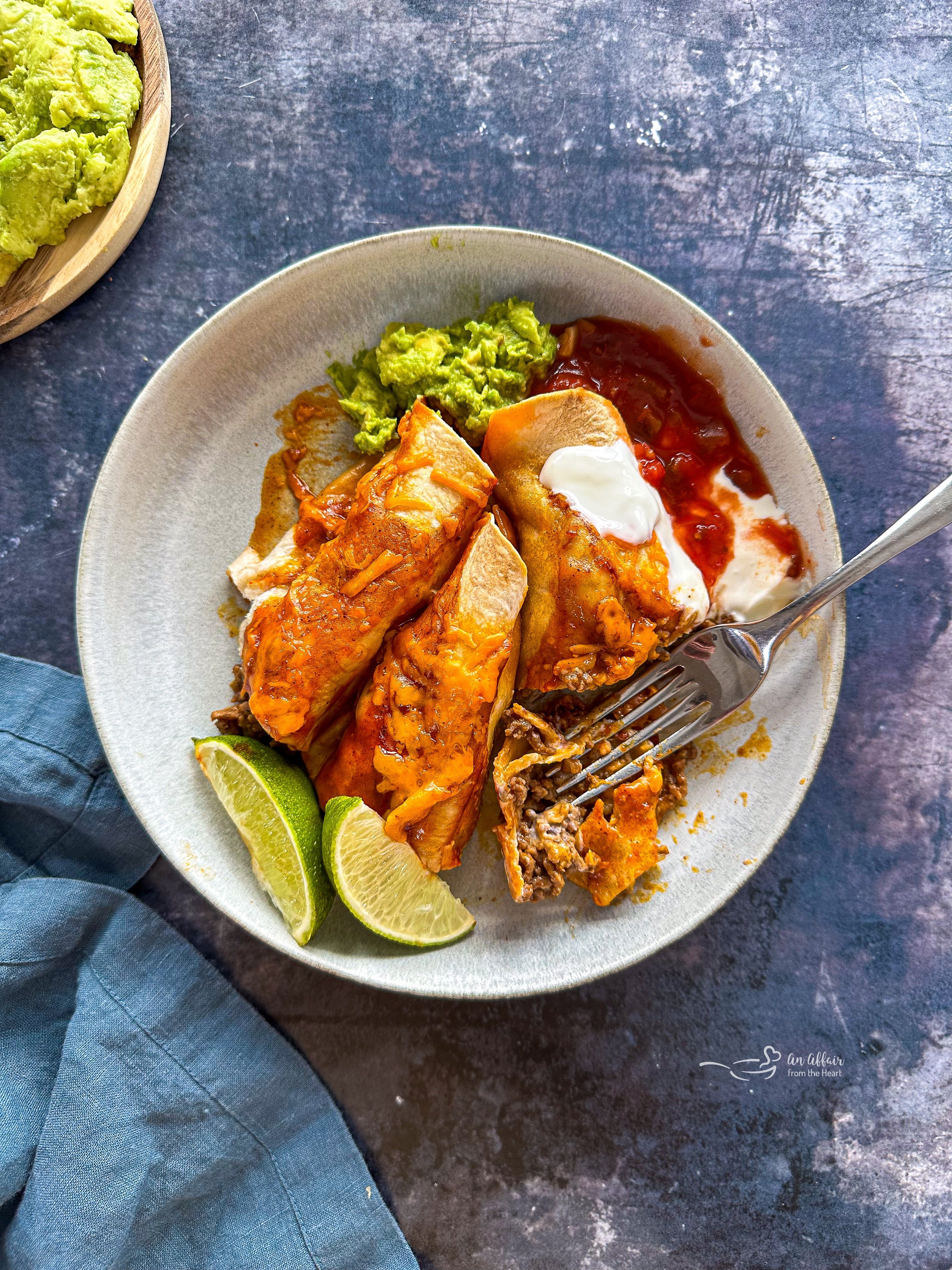 Fork cutting an enchilada to eat.