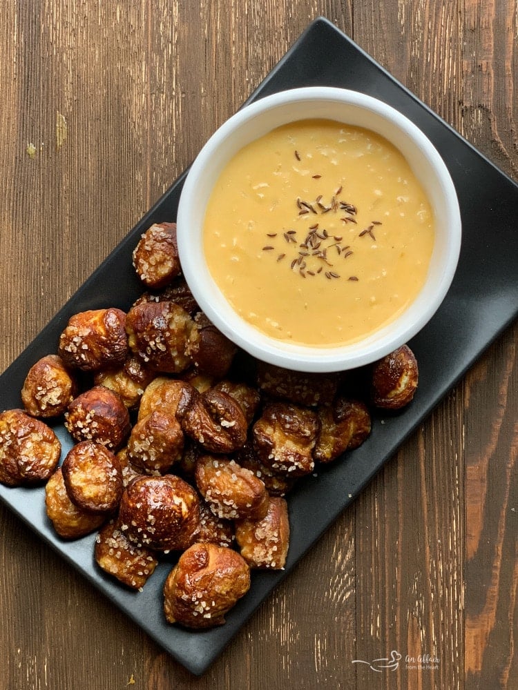 Overhead of Quick Pretzel Bites with Sauerkraut Cheddar Cheese Sauce dip plated